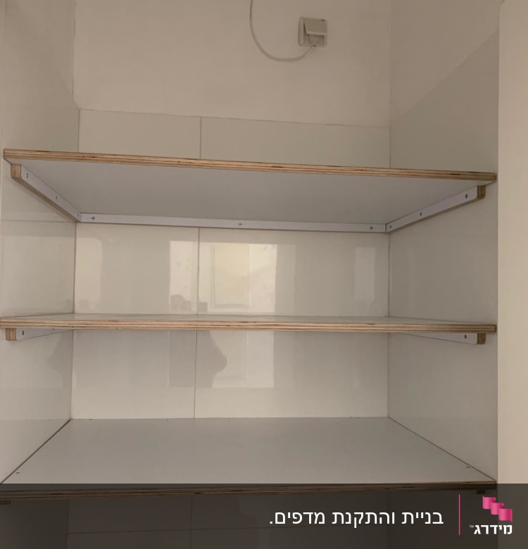 שלושה מדפי עץ מותקנים על קיר לבן